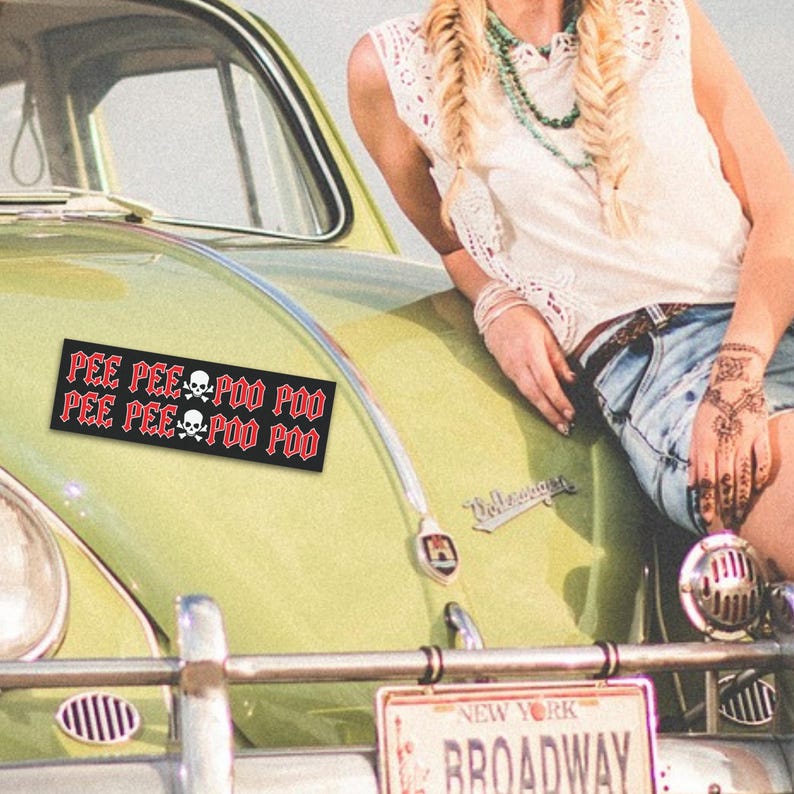 Puede incluir: Un coche vintage amarillo con un parachoques negro y una matr&iacute;cula que dice "NEW YORK BROADWAY". El coche tiene una pegatina negra y roja en el cap&oacute; que dice "PEE PEE POO POO PEE PEE POO POO".