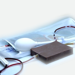 Könnte beinhalten: Eine weiße medizinische Tasche mit einem transparenten Netzfenster, einer weißen Birne und einem roten Schlauch. Die Tasche befindet sich auf einer weißen Oberfläche mit einem braunen rechteckigen Objekt.