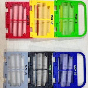 Op de afbeelding: Vier plastic filterroosters met een handvat. De roosters zijn rood, geel, groen en blauw. Elk rooster heeft de tekst "S1 40W" erop gedrukt.