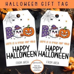 以下が含まれることがあります： ゴーストとカボチャが描かれた、印刷可能なハロウィンのギフトタグ2枚セット。タグには「Boo! これはあなたへのご褒美です！ハッピーハロウィン、アリアより」というメッセージが書かれています。