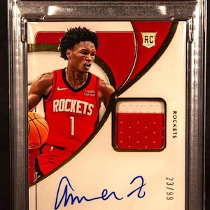 Puede incluir: Tarjeta coleccionable de baloncesto de Amen Thompson de la colección Immaculate 2023. Presenta una firma de parche, una foto de Thompson con la camiseta de los Rockets y el texto "CHASER!!". La tarjeta está calificada y en un soporte protector.