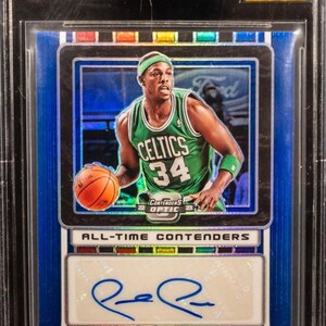 Puede incluir: Una tarjeta de baloncesto de Paul Pierce calificada de la serie Panini Contenders Optic 2022-23. La tarjeta presenta una firma y el texto "CHASER!!". La tarjeta está calificada con 9.5 por Beckett.