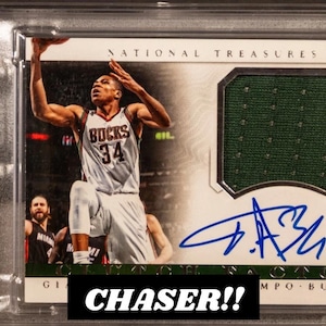 以下が含まれることがあります： バックスのジャージを着たヤニス・アデトクンボのバスケットボールトレーディングカード。サインと緑のジャージのスウォッチ付き。カードはグレーディングされ、エンケースされており、下部に「CHASER!!」というテキストがあります。