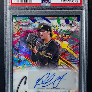 Może przedstawiać: Karta baseballowa 2024 Bowman's Best Paul Skenes Showpieces Autograph, oceniona na GEM MT 10 przez PSA. Karta przedstawia kolorowe abstrakcyjne tło i zawodnika w stroju baseballowym.