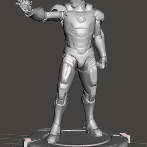 May include: A grey, metallic, detailed figurine of a superhero standing on a circular base. The figurine has a helmet with a visor and a detailed suit with a chest piece.