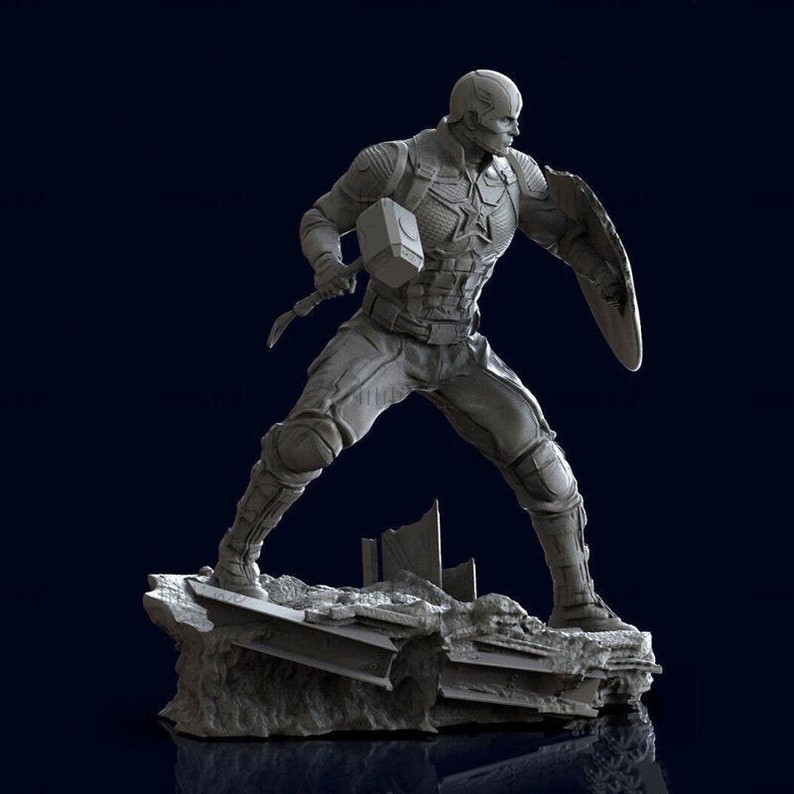 Puede incluir: Una figura gris y detallada de Capit&aacute;n Am&eacute;rica sosteniendo el martillo de Thor, Mjolnir, y un escudo. La figura est&aacute; de pie sobre una base rocosa rota.