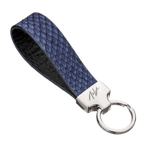 May include: A blue snakeskin leather keyring with a silver key ring and a silver tag with a signature.