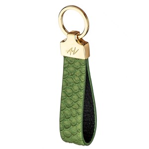 May include: A green leather keychain with a gold ring and a gold plate with the initials "A+V" engraved on it.