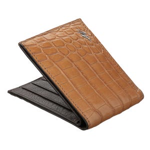 May include: A brown leather wallet with a crocodile pattern and a silver logo. The wallet is folded in half and the inside is visible.