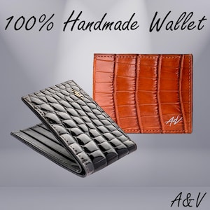 May include: Two leather wallets, one black and one brown, with a crocodile pattern. The wallets are 100% handmade and feature the initials "A&V" on the brown wallet.