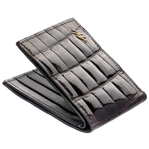 May include: A brown alligator leather wallet with a gold logo. The wallet is folded in half and has a black leather interior.
