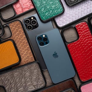 May include: A collection of phone cases with different patterns and colors, including red, green, brown, and black. The cases are made of leather and have a textured finish. The cases are designed to fit a variety of phone models.