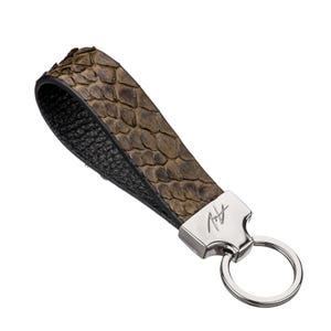 May include: A brown leather key chain with a silver ring and a silver tag with the initials "A.H." embossed on it.