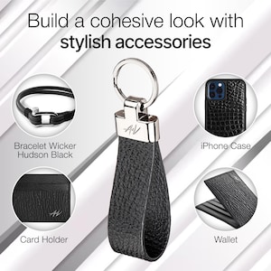 以下が含まれることがあります： シルバーのキーホルダー、カードホルダー、財布、ブレスレット、iPhoneケースが付いたブラックレザーアクセサリーのセット。すべてのアイテムは、テクスチャ加工されたレザーデザインとシルバーのロゴが特徴です。