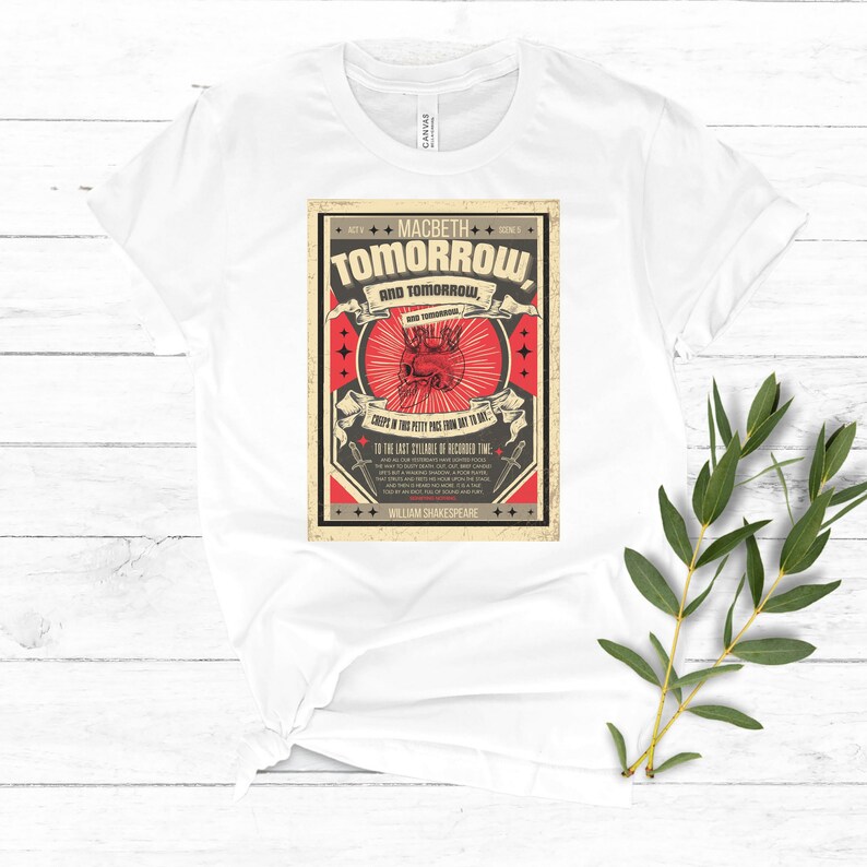 May include: A white t-shirt with a vintage-style graphic print featuring a red heart with a skull inside. The graphic includes the text "MACBETH TOMORROW AND TOMORROW, AND TOMORROW, CREeps IN THIS PETTY PACE FROM DAY TO DAY, TO THE LAST SYLLABLE OF RECORDED TIME, WILLIAM SHAKESPEARE".