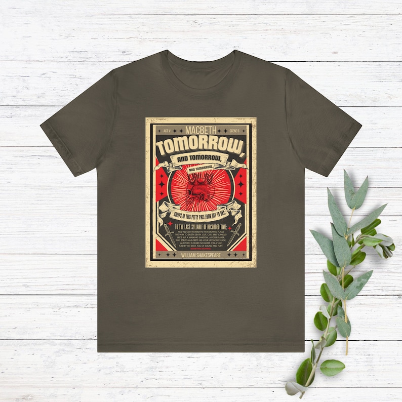 May include: A dark green t-shirt with a vintage-style graphic print of a red heart with a crown and the text "Tomorrow and tomorrow and tomorrow" from Shakespeare's Macbeth. The graphic is surrounded by a red and white border with stars and the text "Act V Scene V".