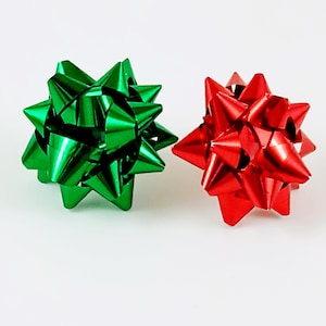 May include: Two decorative gift bows, one green and one red, with a starburst shape.