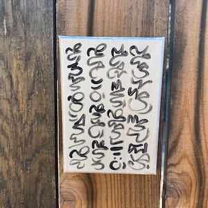 May include: A white canvas with black handwritten text. The text includes the words "remarkable", "love", "3", "2", "you", "are", "amazing", "and", "so", "much", "more".