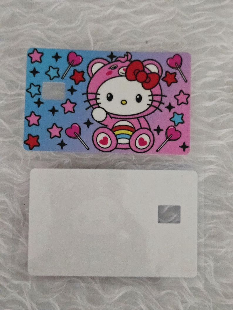 May include: Two rectangular cards. The top card features a colorful design with a cartoon cat in a pink outfit, surrounded by stars and heart-shaped lollipops. The bottom card is plain white.