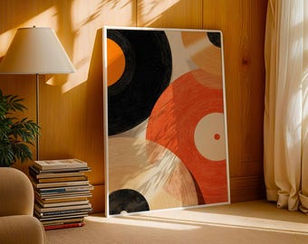 May include: A framed art print featuring a collage of vinyl records in shades of black, orange, and red. The artwork is displayed in a well-lit room with a lamp, a stack of books, and a beige armchair.