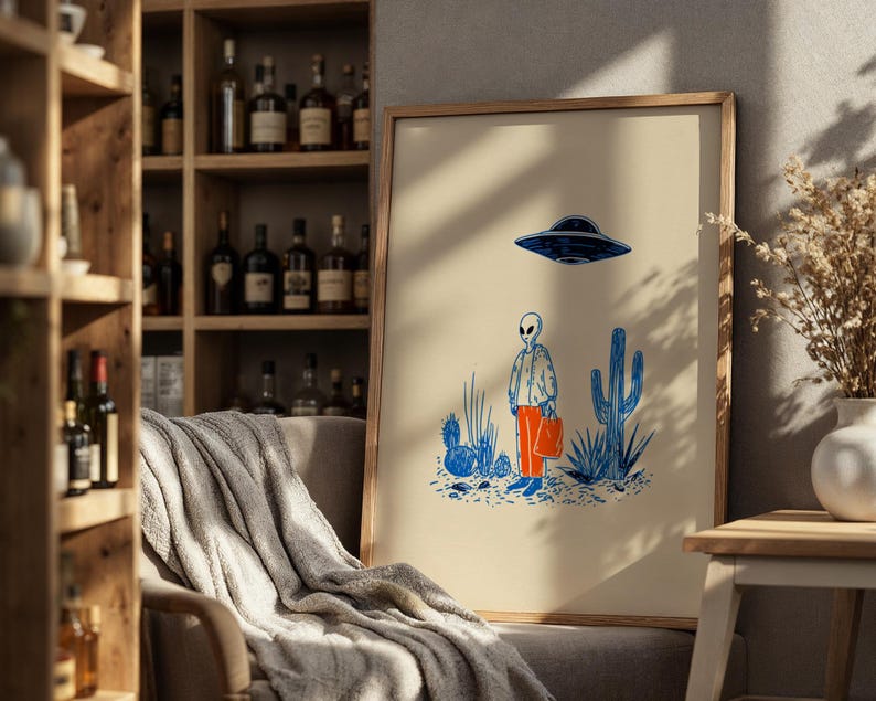 Retro alien UFO wall art featuring a quirky extraterrestrial walking through a desert landscape with cactus plants under a hovering spaceship. Bold blue and orange accents add a playful modern touch to the minimalist sci-fi illustration. Perfect for game rooms, living rooms, or offices, this unique artwork brings humor, character, and a creative sci-fi vibe to any interior. Ideal for space lovers and geek decor.