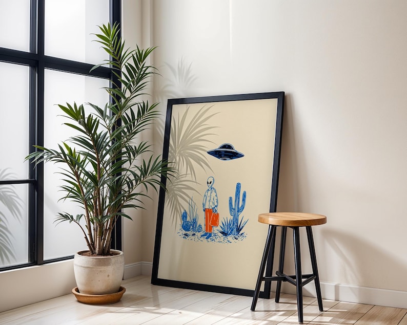 Retro alien UFO wall art featuring a quirky extraterrestrial walking through a desert landscape with cactus plants under a hovering spaceship. Bold blue and orange accents add a playful modern touch to the minimalist sci-fi illustration. Perfect for game rooms, living rooms, or offices, this unique artwork brings humor, character, and a creative sci-fi vibe to any interior. Ideal for space lovers and geek decor.