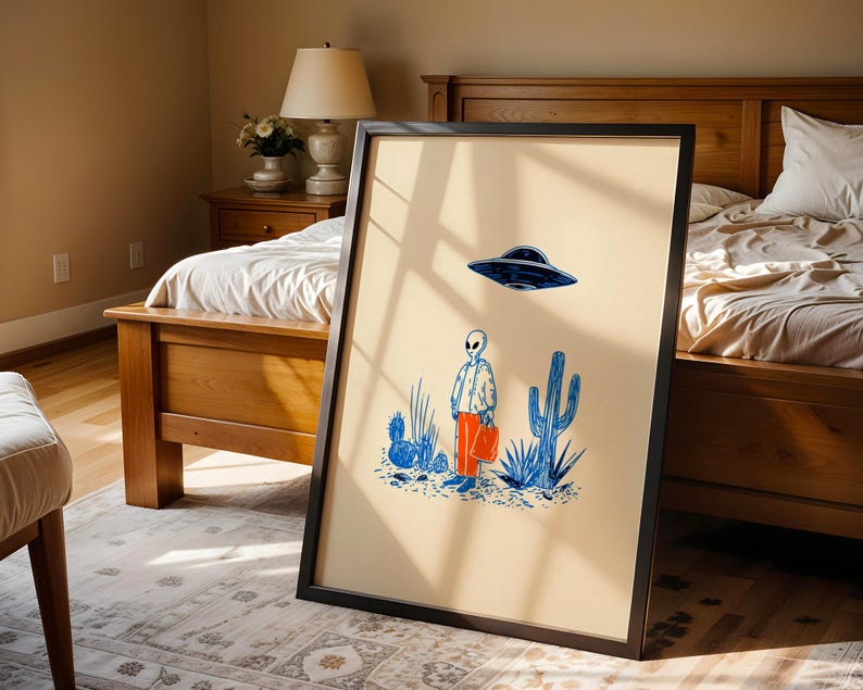 Retro alien UFO wall art featuring a quirky extraterrestrial walking through a desert landscape with cactus plants under a hovering spaceship. Bold blue and orange accents add a playful modern touch to the minimalist sci-fi illustration. Perfect for game rooms, living rooms, or offices, this unique artwork brings humor, character, and a creative sci-fi vibe to any interior. Ideal for space lovers and geek decor.