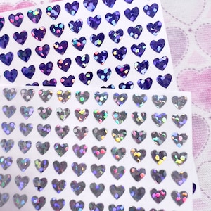 May include: A sheet of iridescent heart-shaped stickers. The hearts are silver with a holographic finish.