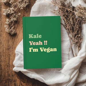 May include: A green journal with the text "Kale Yeah!! I'm Vegan" in yellow, pink, and orange letters.