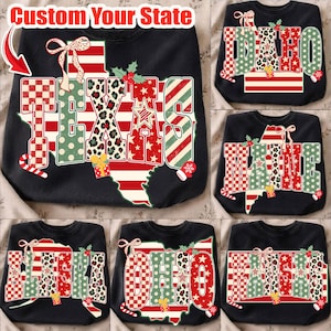 May include: A black sweatshirt featuring a graphic of the state of Texas with the text "TEXAS" filled with red, white, and green patterns including stripes, polka dots, leopard print, and stars, accented with a bow, holly, and a gift box.