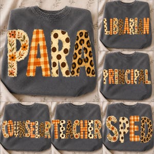 May include: A charcoal gray crewneck sweatshirt featuring large block letters with varied patterns including orange floral, orange plaid, brown polka dots, and leopard print. The text options displayed are PARA, LIBRARIAN, PRINCIPAL, COUNSELOR, TEACHER, and SPED.