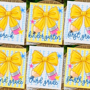 May include: A collection of six rectangular signs featuring a yellow pencil-shaped bow graphic, blue and white gingham or yellow striped backgrounds, and colorful stars. Each sign displays a specific grade level in blue script: pre-k, kindergarten, first grade, second grade, third grade, and fourth grade.