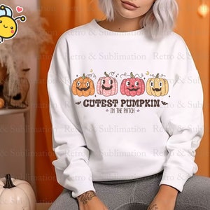 Może przedstawiać: Biała bluza z nadrukiem czterech uśmiechniętych dyni i tekstem "Cutest Pumpkin in the Patch".