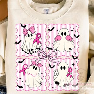 May include: Cream-colored sweatshirt featuring a pink and white striped design with four cartoon ghosts. Each ghost has a pink ribbon, bow, or boxing gloves. Black bats and stars surround the ghosts. The design is a digital print.