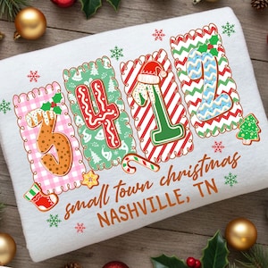 May include: White Christmas-themed towel with the numbers "3412" in a gingerbread cookie design. The towel has the text "small town christmas NASHVILLE, TN" in a brown script font, with snowflakes and Christmas decorations.