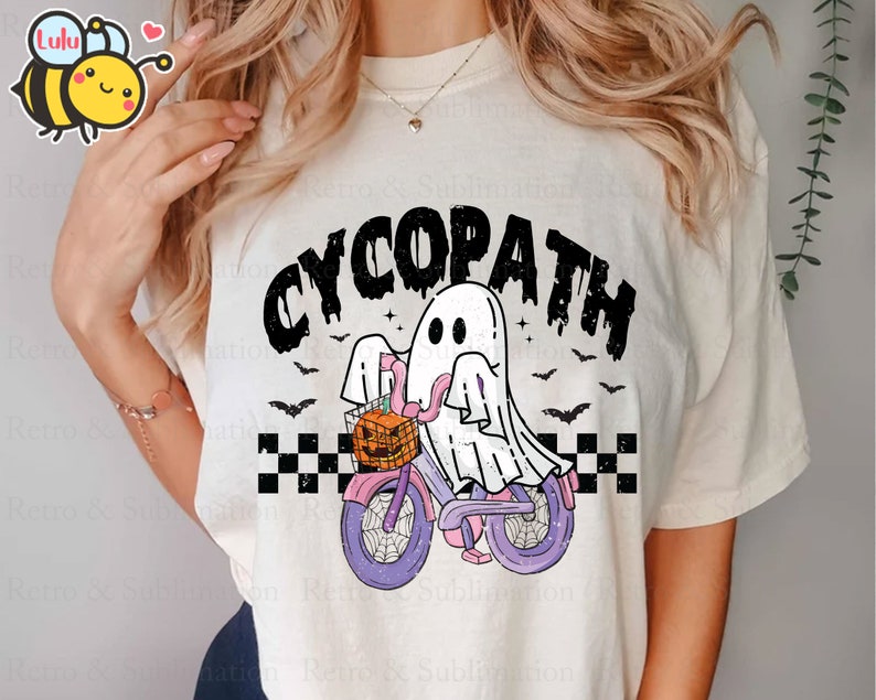 May include: White t-shirt with a black and white graphic of a ghost riding a bicycle with a pumpkin in the basket. The text "CYCOPATH" is above the ghost.