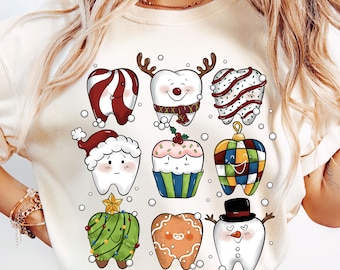 May include: A white t-shirt with a Christmas-themed design featuring cartoon teeth dressed up as various holiday characters, including a snowman, a gingerbread man, a candy cane, a Christmas tree, and a cupcake.