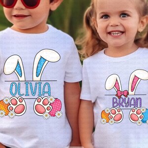 May include: Two white t-shirts with bunny ears and Easter egg designs. The shirts have the names "Olivia" and "Bryan" printed on them.