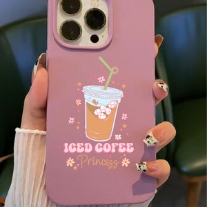 Puede incluir: Una funda de iPhone rosa con una ilustraci&oacute;n de dibujos animados de una taza de caf&eacute; helado con una pajita y flores. El texto "ICED COFFEE Princess" est&aacute; impreso en la funda.