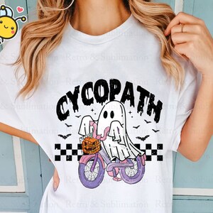 May include: White t-shirt with a black and white graphic of a ghost riding a bicycle with a pumpkin basket. The text "CYCOPATH" is above the ghost.