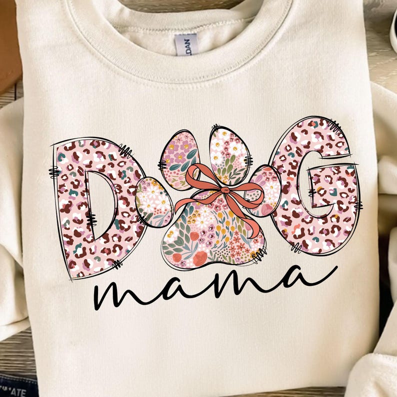 May include: A cream-coloured sweatshirt with a pink and brown floral design that says "Dog mama".