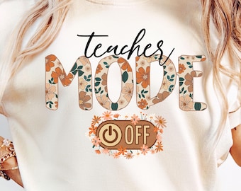 May include: A white t-shirt with the text "teacher mode" in brown and black letters with a floral pattern. The word "mode" is larger than the word "teacher". Below the text is a brown and orange switch with the word "off" in white letters. The switch is surrounded by a floral pattern.