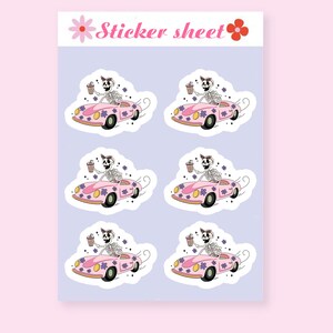May include: A sheet of four stickers featuring a pink car with a skeleton driving and holding a drink. The car has purple flowers on it and the skeleton is wearing a headband with a bow. The background is light purple.
