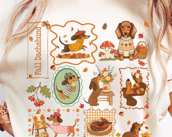 Op de afbeelding: Een crèmekleurig t-shirt met een grafische print van teckels in herfstachtige omgevingen. Het ontwerp bevat de tekst "Fall Dachshund" en diverse illustraties van honden die truien dragen, met bladeren spelen en omringd zijn door herfstmotieven.