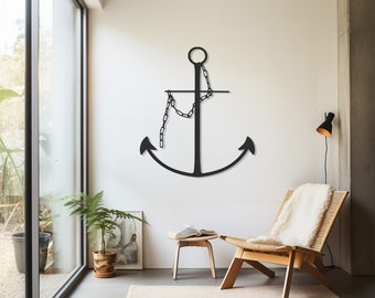 May include: A large, black metal anchor wall art piece with a chain, mounted on a white wall. The anchor is a nautical-themed decoration, suitable for a living room or bedroom. The room also features a chair, rug, and a small table.