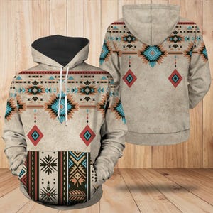 May include: A beige hoodie with a black-lined hood and a Southwestern-inspired pattern. The design features geometric shapes in teal, red, brown, and black. The front pocket area has a contrasting pattern.