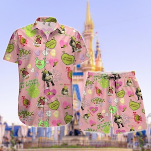 Może przedstawiać: Różowy zestaw koszuli i szortów z motywem Shreka. Koszula jest zapinana na guziki z krótkimi rękawami, a szorty mają sznurek. Wzór zawiera postacie Shreka, serca i frazy takie jak "Get Into My Swamp".