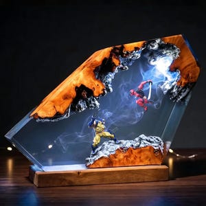 Peut inclure: Une lampe décorative composée d'un bloc de résine transparente incrusté de bois naturel, mettant en scène des figurines miniatures de Wolverine et Deadpool en plein combat. L'objet intègre un éclairage illuminant des effets de fumée.