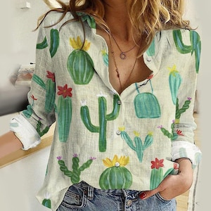 Puede incluir: Una camisa blanca de manga larga con botones y estampado de cactus verde, amarillo y rosa.