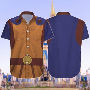 May include: Short-sleeved button-down shirt featuring a Hercules-inspired design. The front showcases a tan and brown vest-like pattern with a gold medallion. The sleeves and back are solid blue, with brown shoulder accents. The shirt has a classic collar.